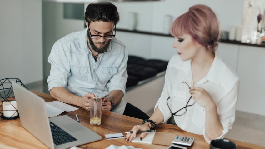 Young Couple paying bills using smartphone technology.