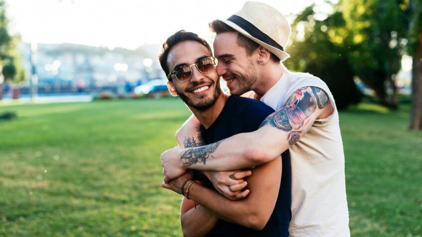 Gay couple traveling across Europe and having farewell moment after spending memorable moments together.