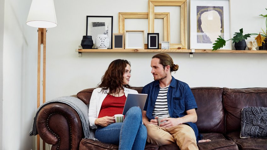 Shot of a young couple relaxing on the sofa with a digital tablet at home.