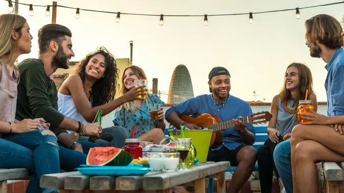 Young adults celebrating life and friendship on a rooftop in Barcelona, Spain.