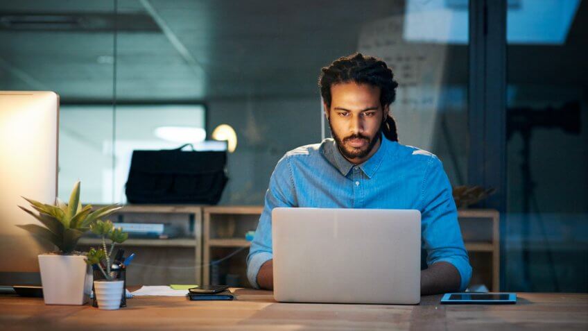 Cropped shot of a young designer working late on a laptop in an office.