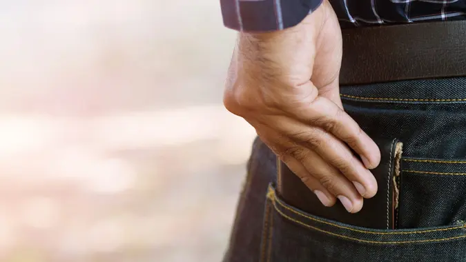 Man putting wallet in his back pocket.