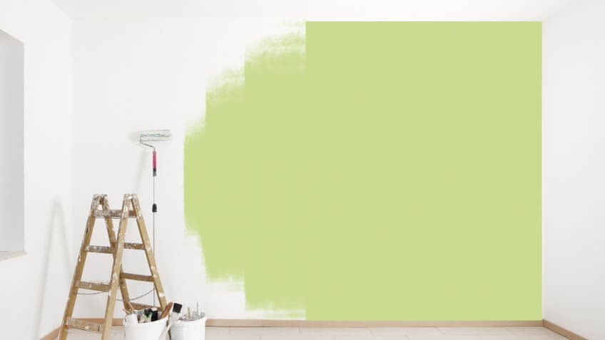painting green wall with ladder