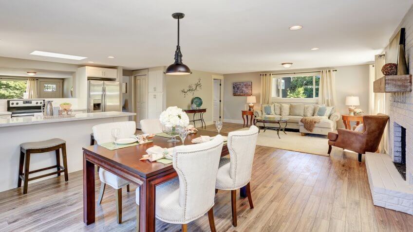 Open floor plan dining area with elegant table setting and white soft chairs