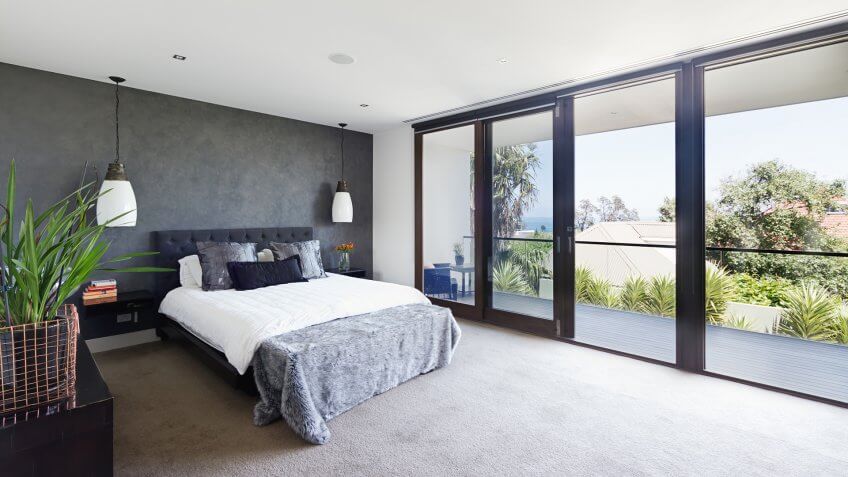 Spacious interior of designer master bedroom in luxury contemporary Australian home.