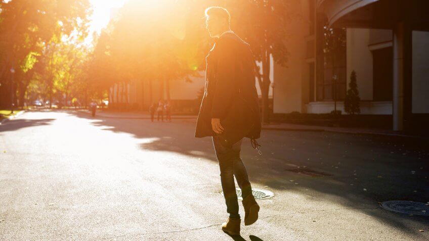Hipster guy walking down the street, urban style.