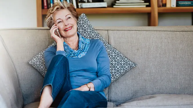 Shot of a relaxed senior woman using a phone at home on the sofa.