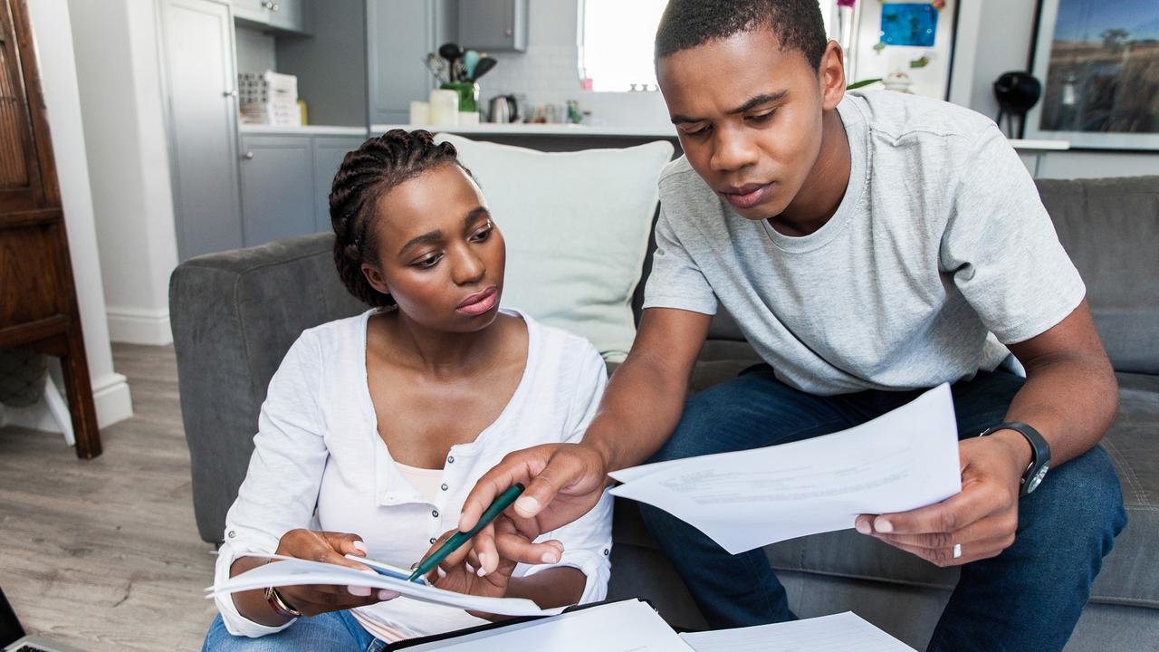 Young african female and male couple at home working on their finances together.