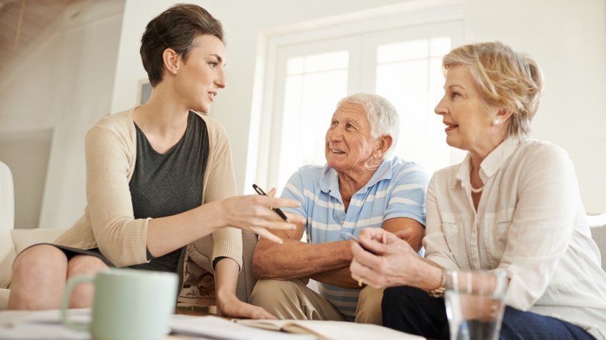 Shot of a senior couple getting advice from their financial consultant in their living room.
