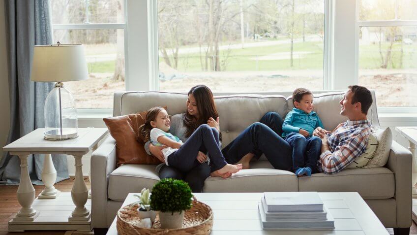Shot of a happy young family of four relaxing together on the sofa at home.