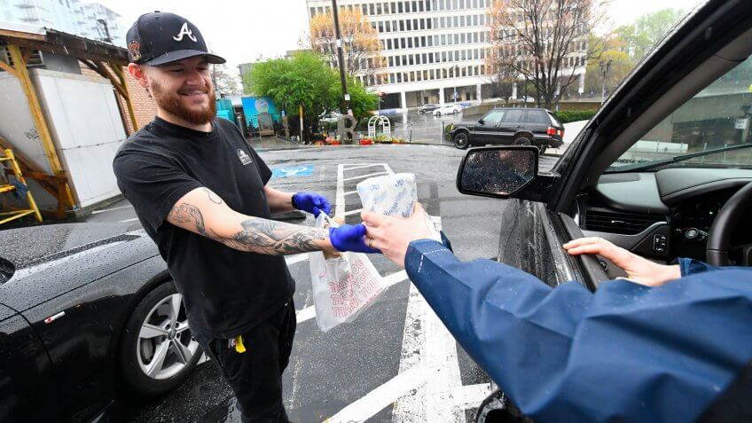 Bell Street Burittos manager Cesar Chavez hands a free roll of toilet paper to a customer as he brings out his order, in Atlanta, Georgia, USA, 23 March 2020.