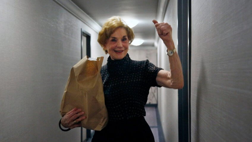 Carol Sterling, 83, gives a thumbs-up to Liam Elkind after he delivers groceries to her apartment as part of a newly formed volunteer group he cofounded, Invisible Hands.