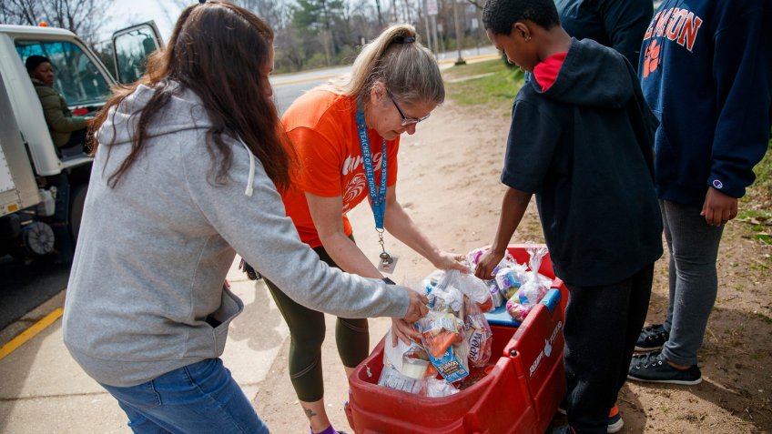 Fairfax County Public Schools food service workers hand out free lunches to students while schools are closed due to the COVID-19 coronavirus pandemic at Mosby Woods School in Fairfax, Virginia, USA, 19 March 2020.