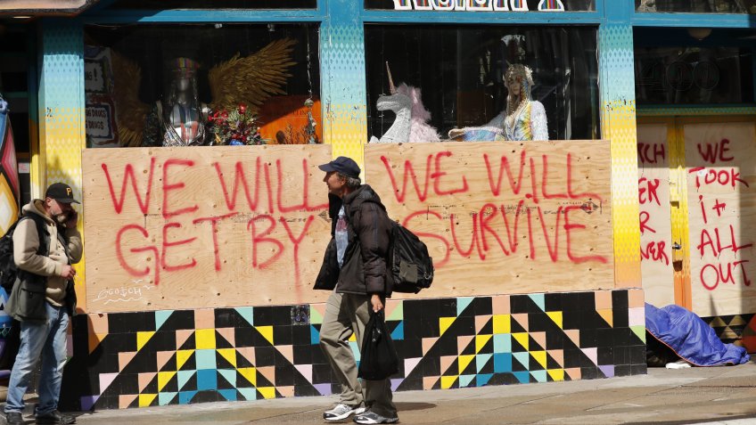 A boarded window at a closed store with a message in the Haight-Ashbury district, 'We Will Get By, We Will Survive' in San Francisco, California, USA, 18 March 2020.
