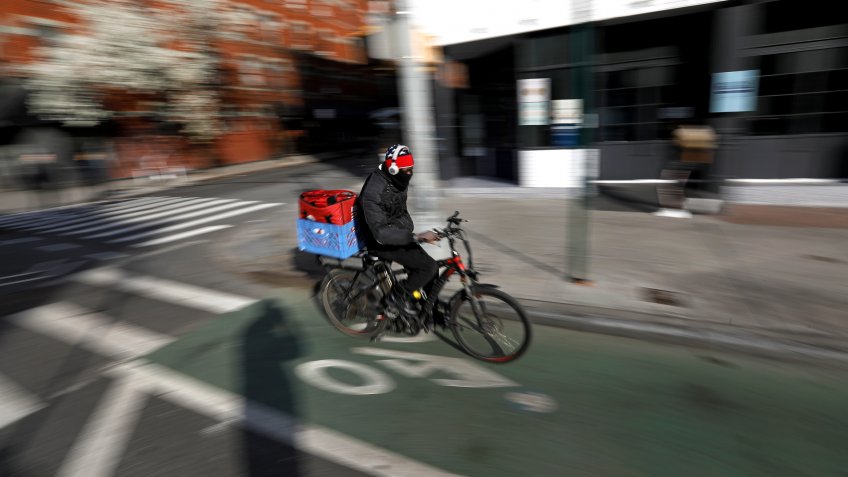 A food delivery person rides down Ninth Avenue in New York, New York, USA, 22 March 2020.