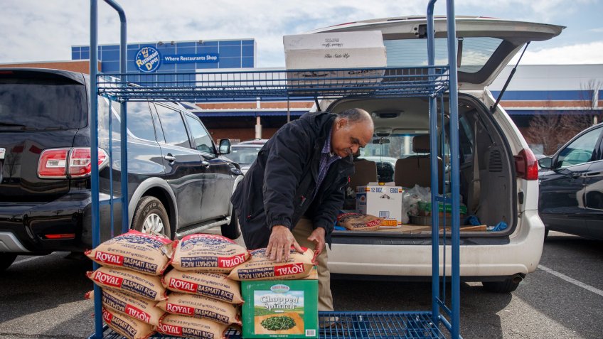 A shopper loads his vehicle at Restaurant Depot, a restaurant supply warehouse, amid the COVID-19 coronavirus pandemic in Alexandria, Virginia, USA, 21 March 2020.
