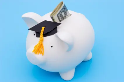 Piggy bank with a graduation cap on blue background